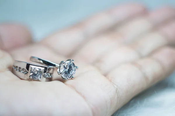 Designer wedding rings in the corner on a sparkling glitter background in panoramic banner format with copy space and selective focus