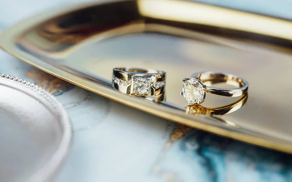 コピースペースと選択的フォーカスを持つパノラマバナー形式の輝く輝きの背景に隅にデザイナーの結婚指輪 — ストック写真