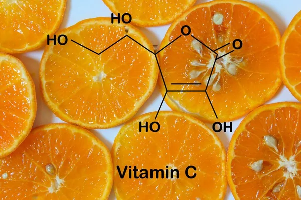 オレンジスライスの背景にあるビタミンCの構造式 — ストック写真