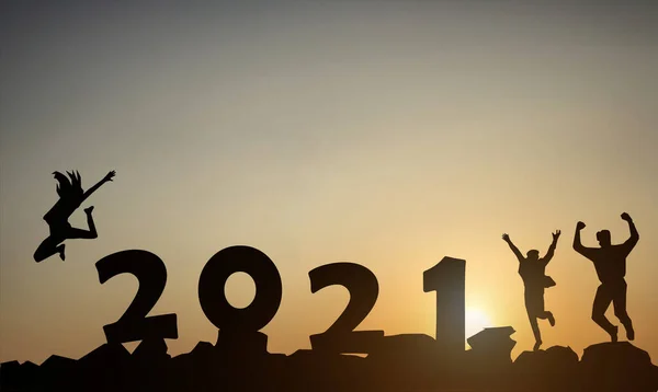 朝の日差しの背景に対して日没の山で2021年の数字でジャンプする人々のシルエット — ストック写真