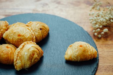 Tahta bir masaya yerleştirilmiş körili puf böreği..