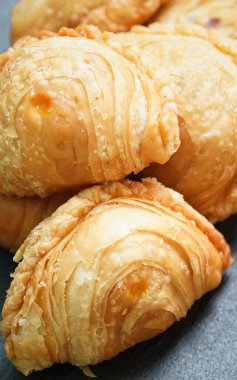 Tahta bir masaya yerleştirilmiş körili puf böreği..