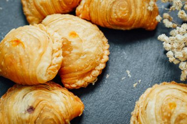 Tahta bir masaya yerleştirilmiş körili puf böreği..