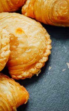 Tahta bir masaya yerleştirilmiş körili puf böreği..