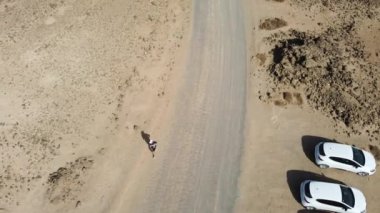 Fuerteventura Adası 'nın kuzeyindeki Corralejo kasabası yakınlarındaki Popcorn Sahili kıyısında koşan genç bir adam. İspanya, 4k video