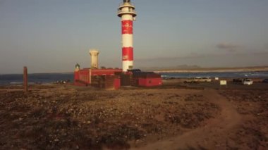Gün batımında, El Cotillo, Kanarya Adaları yakınlarındaki Punta Ballena, Fuerteventura 'daki Toston deniz fenerinde hava manzarası. İspanya, 4k video