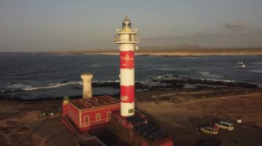 Gün batımında, El Cotillo, Kanarya Adaları yakınlarındaki Punta Ballena, Fuerteventura 'daki Toston deniz fenerinde hava manzarası. İspanya, 4k video
