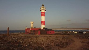 Fuerteventura 'daki Toston deniz fenerinde gün batımı, Punta Ballena, El Cotillo, Kanarya Adaları yakınlarındaki kasaba. İspanya, 4k video