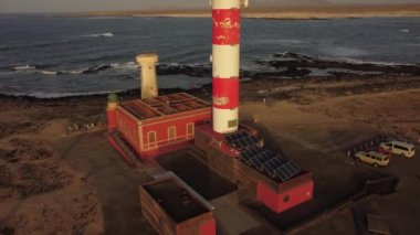 Fuerteventura 'daki Toston deniz fenerinde gün batımı, Punta Ballena, El Cotillo, Kanarya Adaları yakınlarındaki kasaba. İspanya, 4k video