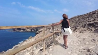 Fuerteventura, Kanarya Adaları 'nın batı kıyısındaki Cuevas de Ajuy, Pajara' da yürüyen genç bir turist. İspanya, video 4k