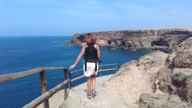 Fuerteventura, Kanarya Adaları 'nın batı kıyısındaki Cuevas de Ajuy, Pajara' da yürüyen genç bir turist. İspanya, video 4k