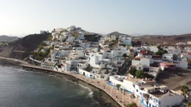 Sahilin ve Kanarya Adaları 'ndaki Fuerteventura adasının doğu kıyısındaki Las Playitas sahil kasabasının havadan görüntüsü. İspanya, 4k video