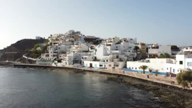 Sahilin ve Kanarya Adaları 'ndaki Fuerteventura adasının doğu kıyısındaki Las Playitas sahil kasabasının havadan görüntüsü. İspanya, 4k video