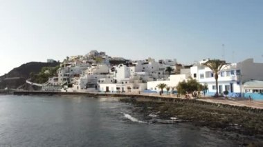 Sahilin ve Kanarya Adaları 'ndaki Fuerteventura adasının doğu kıyısındaki Las Playitas sahil kasabasının havadan görüntüsü. İspanya, 4k video