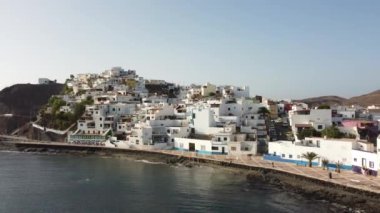 Sahilin ve Kanarya Adaları 'ndaki Fuerteventura adasının doğu kıyısındaki Las Playitas sahil kasabasının havadan görüntüsü. İspanya, 4k video