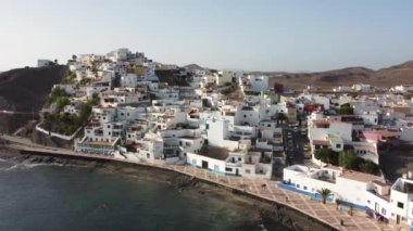 Sahilin ve Kanarya Adaları 'ndaki Fuerteventura adasının doğu kıyısındaki Las Playitas sahil kasabasının havadan görüntüsü. İspanya, 4k video