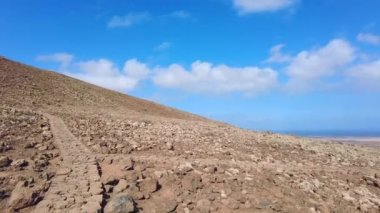 Kanarya Adaları 'ndaki Fuerteventura adasının kuzey kıyısındaki Corralejo yakınlarındaki Caldern Hondo volkanı kraterine giden taş yolu. İspanya