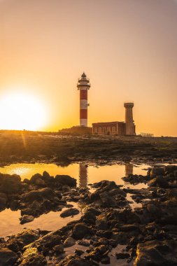 Deniz kenarındaki Toston Deniz Feneri 'nde gün batımı, El Cotillo kasabası yakınlarındaki Punta Ballena, Fuerteventura Adası, Kanarya Adaları. İspanya