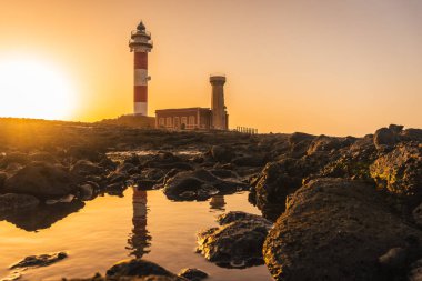 Deniz kenarındaki Toston Deniz Feneri 'nde günbatımında yansıyan deniz feneri Punta Ballena, El Cotillo kasabası yakınlarında, Fuerteventura Adası, Kanarya Adaları. İspanya
