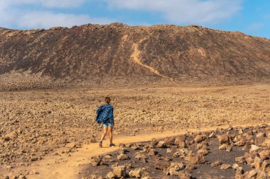 Genç bir kadın, Kanarya Adaları, Fuerteventura adasının kuzey kıyısındaki Corralejo yakınlarındaki Calderon Hondo volkanı kraterine doğru yol alıyor. İspanya