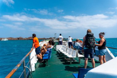 Fuerteventura, Kanarya Adaları 'nın kuzey kıyısındaki Lobos Adası' ndaki turkuaz suya bakan turistler. İspanya