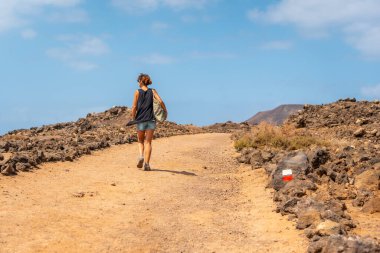 Genç bir kadın, Fuerteventura, Kanarya Adaları 'nın kuzey kıyısı boyunca Lobos Adası' nı ziyaret ediyor. İspanya