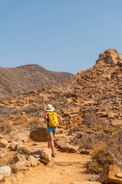 Fuerteventura, Kanarya Adaları 'nın batı kıyısındaki Mirador de la Penitas' a doğru giden kanyon yolunda yürüyen genç bir kadın. İspanya
