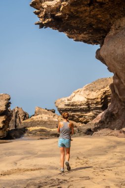 Playa de Garcey 'de tatil yapan genç bir anne, Fuerteventura, Kanarya Adaları' nın batı kıyısında. İspanya