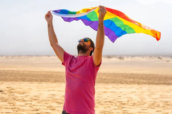 一个拿着Lgbt旗的同性恋者喜欢它在沙漠中随风飘扬 象征同性恋 彩虹旗 — 图库照片
