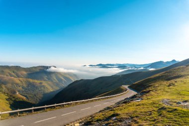 Road at sunrise on top of Mount Larrau. In the forest or jungle of Irati, Pyrenees-Atlantiques of France clipart