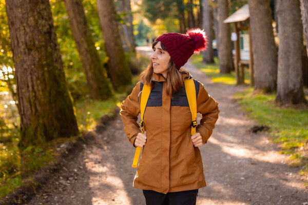 Irati jungle in autumn, lifestyle, a young woman with yellow jacket and woolen hat on the Ochagavia forest trail, northern Navarra in Spain, Selva de Irati