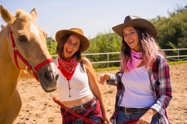 两名女牛仔骑着马站在一匹马旁边 身穿南美服装 — 图库照片