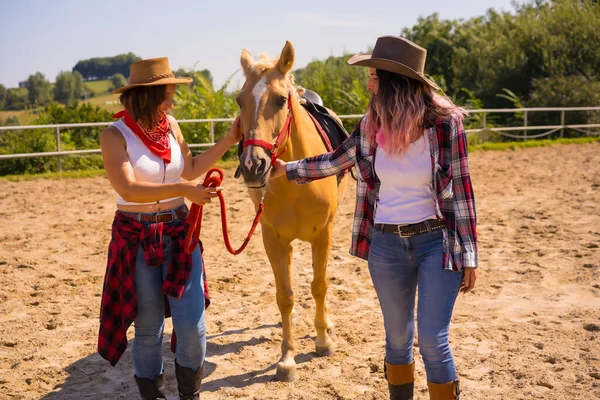 Posieren Von Zwei Cowgirl Frauen Die Mit Einem Pferd Auf — Stockfoto