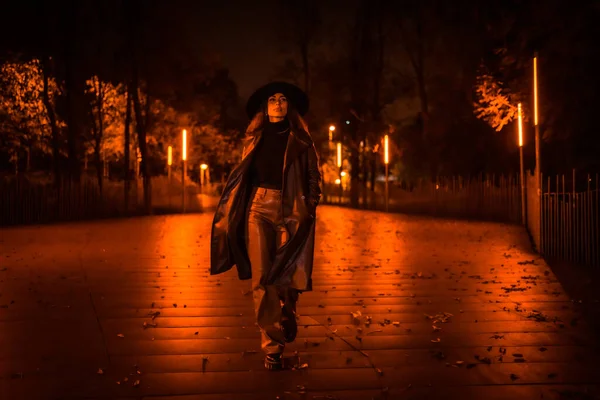 冬天的夜晚 戴帽子的女孩从容地穿过公园 — 图库照片