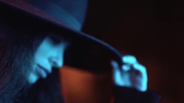 Parkta, mavi ışıkla aydınlatılmış, gece vakti şapkalı, beyaz esmer bir kız. Geceleri kış modası ve yaşam tarzı