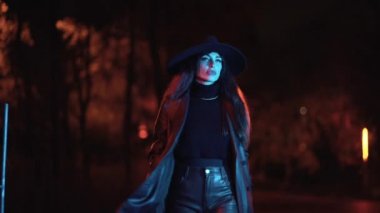 Parkta, mavi ışıkla aydınlatılmış, gece vakti şapkalı, beyaz esmer bir kız. Geceleri kış modası ve yaşam tarzı