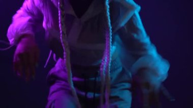 Rap dansçısının neon ışıklarıyla dans etmesi, diskoda mavi ve kırmızı ışıkta dans etmesi, 4K video.
