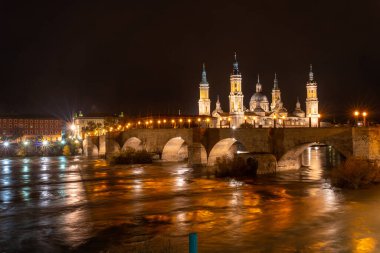 Gece Aragon 'un Zaragoza kentindeki Ebro nehrinde Nuestra Sinyora del Pilar Bazilikası' nın yanındaki Puente de Piedra 'da panoramik. İspanya