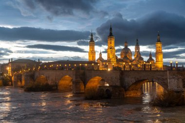 Aragon 'un Zaragoza kentindeki Ebro nehri üzerindeki Basilica De Nuestra Senora del Pilar' ın yanındaki Puente de Piedra 'da alacakaranlık. İspanya