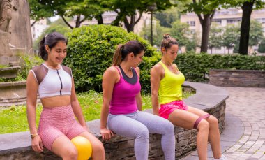 Şehirdeki bir parkta spor yapan Latin bir kız, yaşam tarzı sağlıklı bir hayat, öğretmenlik öğrencilere bacak egzersizleri yaptırıyor.