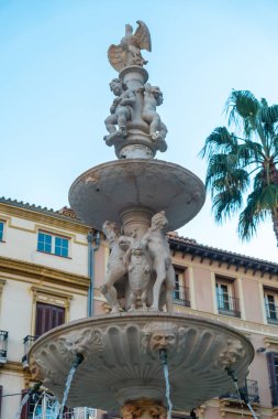 Water fountain in the Plaza de la Constitucion of the city of Malaga and its beautiful palm trees, Andalusia. Spain