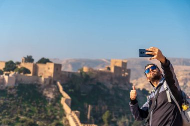 Cerro San Cristobal de la Muralla de Jairan ve Endülüs 'ün Almerya kasabasındaki Alcazaba' nın bakış açısından selfie çeken genç bir turist. İspanya. Costa del Sol Akdeniz 'de