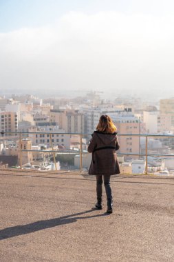 Gündoğumunda genç bir turist kız Cerro San Cristobal ve arka planda Almeria şehri, Endülüs 'te. İspanya. Costa del Sol Akdeniz 'de