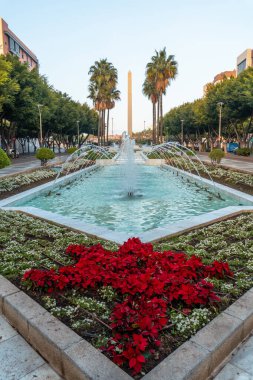 Günbatımında, Endülüs 'te Rambla de Almeria' nın Las Belen caddesinde palmiye ağaçlarının yanında çeşme ve çiçekler. İspanya. Costa del Sol Akdeniz 'de