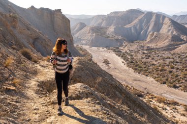 Endülüs 'ün Almerya bölgesindeki Tabernas Çölü' ndeki Rambla de Lanujar kanyonunda yürüyüş yapan genç bir kız. Çölde yolculuk, yaşam tarzı.
