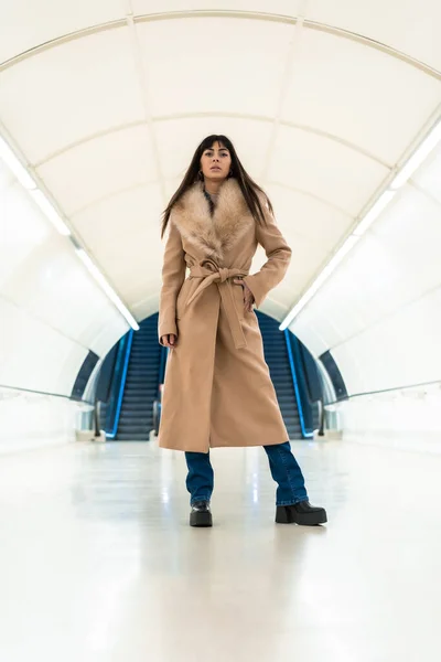 在冬天 一个漂亮的黑发女孩穿着夹克走进地铁 漂亮的白种人穿过隧道 — 图库照片