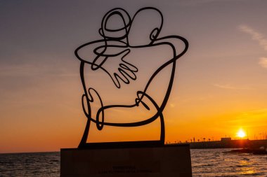 Heykel, Valencia 'nın başkenti Alicante, Torrevieja' daki Playa del Cura 'da turuncu günbatımında covid kurbanlarının lehine. İspanya