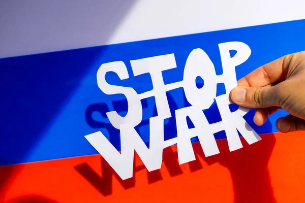 戦争を止め ウクライナとロシアの間の紛争 ロシアの国旗を背景に戦争のスローガンから手を引いた男がぼやけた — ストック写真