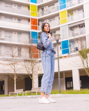 Siyah çantalı, maymun kovboylu, beyaz bir kız. Tatilde şehrin tadını çıkarmak, renkli bir evde genç bir kızın yaşam tarzı.