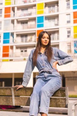 Siyah çantalı, maymun kovboylu, beyaz bir kız. Tatilde şehrin tadını çıkarmak, renkli bir evde oturan genç bir kızın yaşam tarzı.